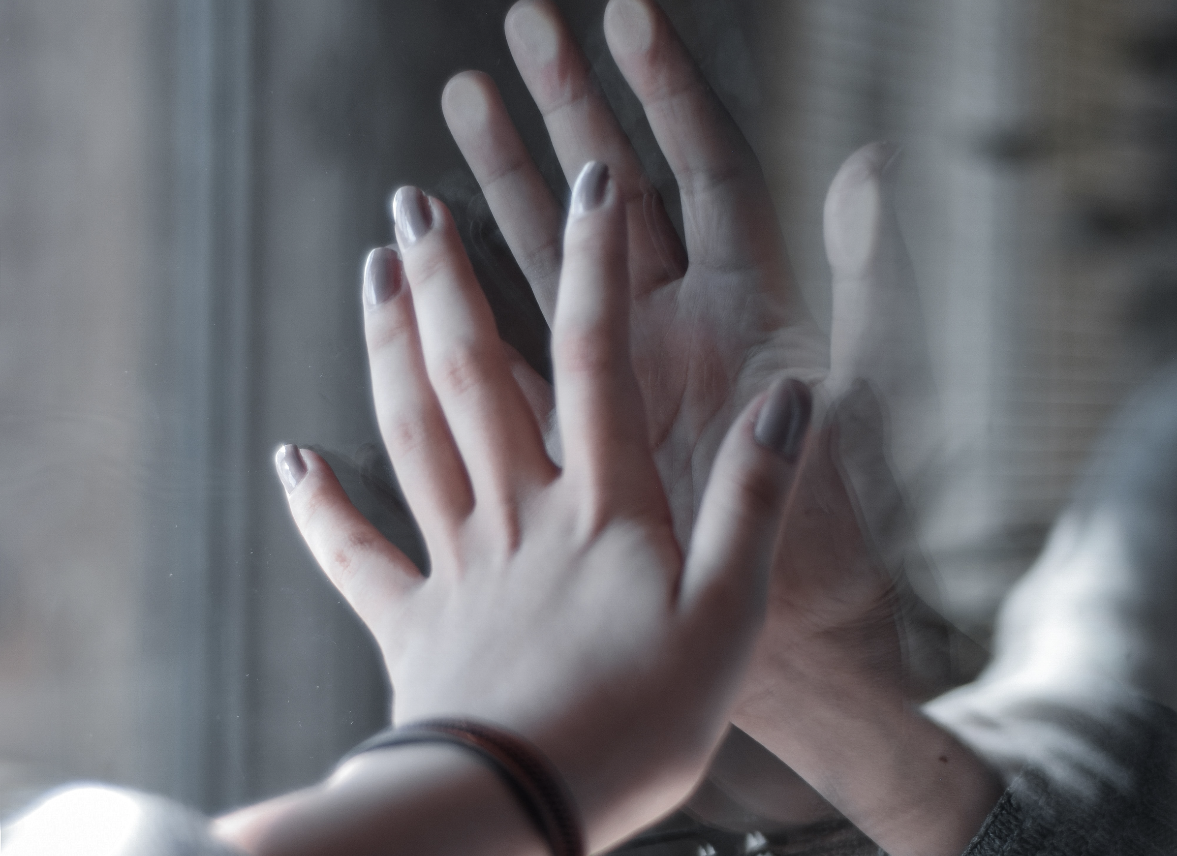 Hands touching through glass