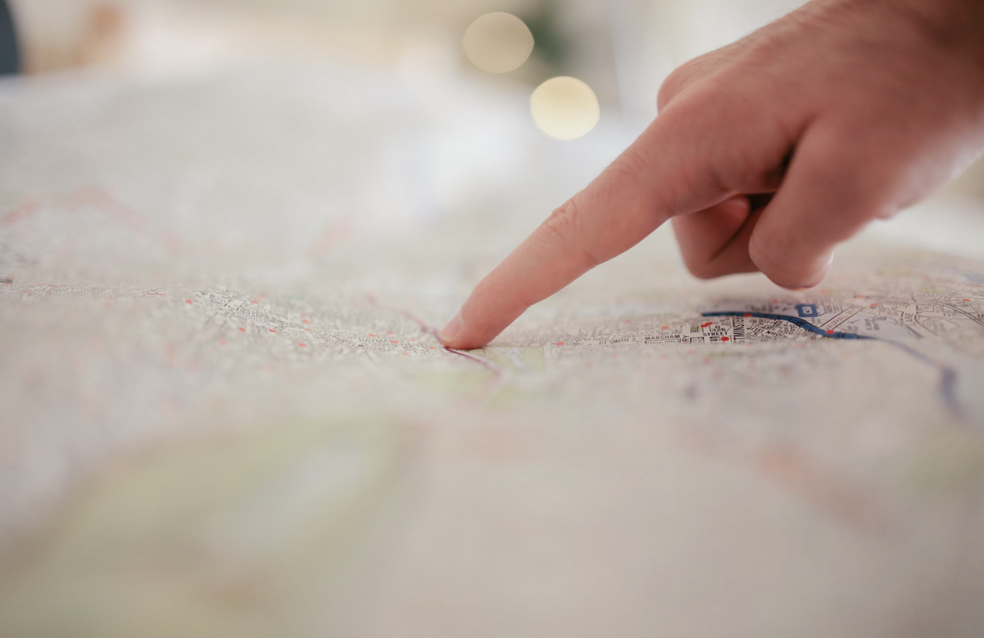 Finger pointing to a location on a map