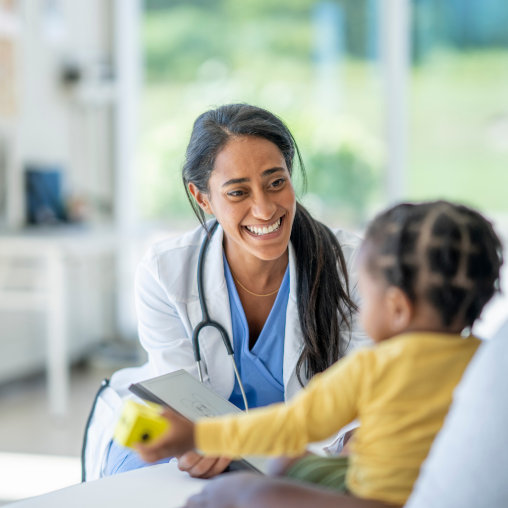 Doctor talking to young child during medical visit.