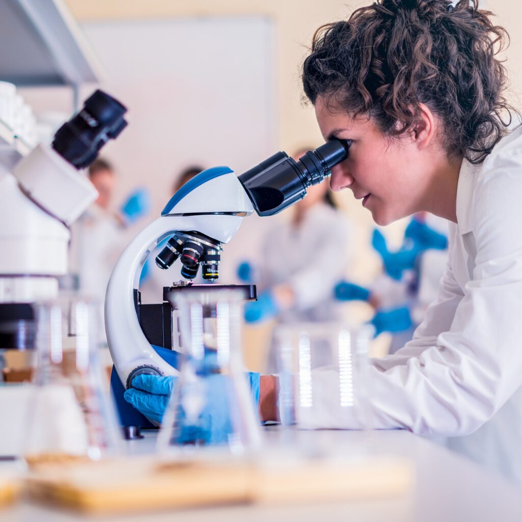researcher looking through a microscope in a science lab.