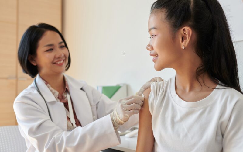 Doctor talking with a parent and child during a medical visit.