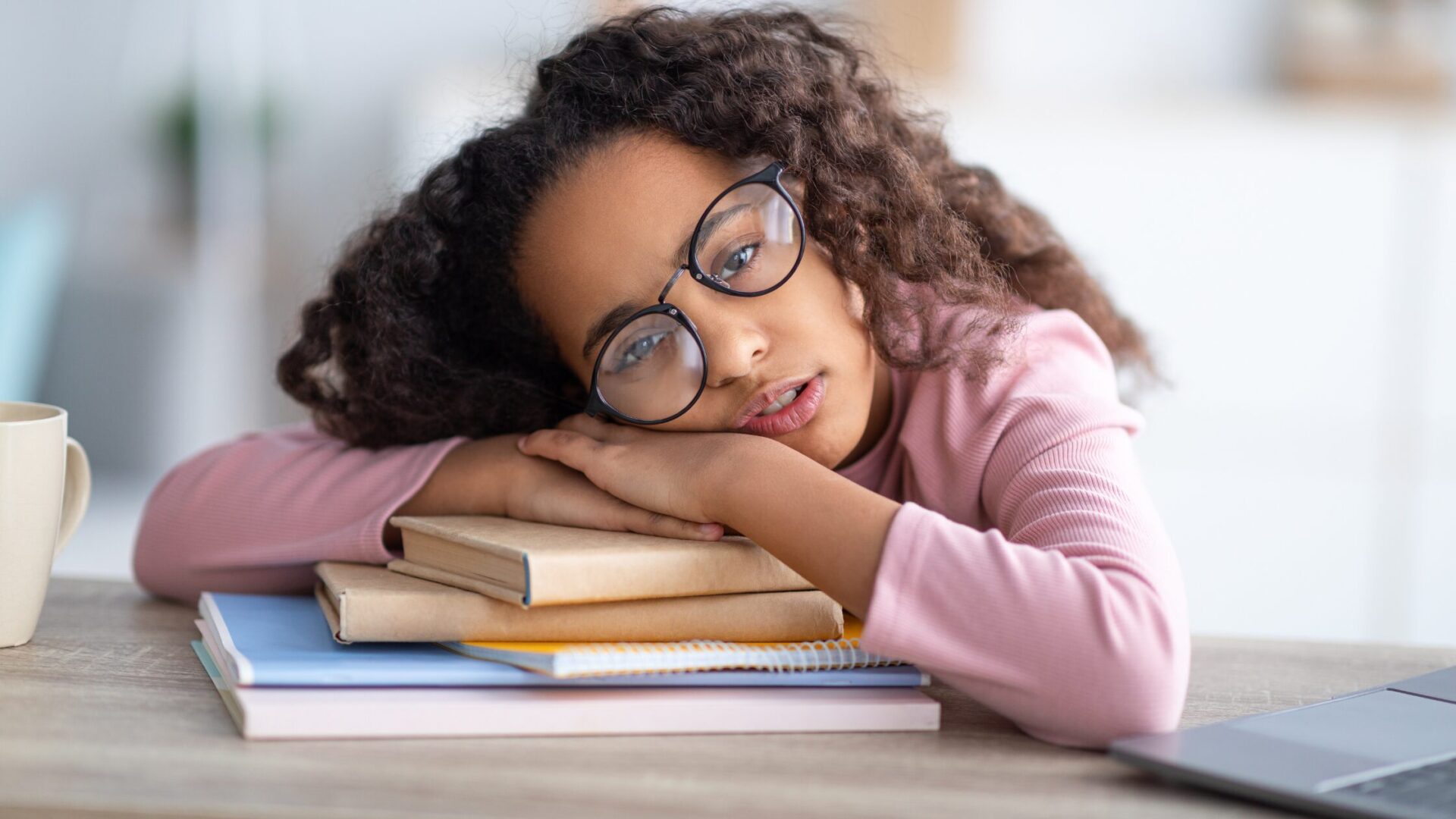 girl with head resting on books