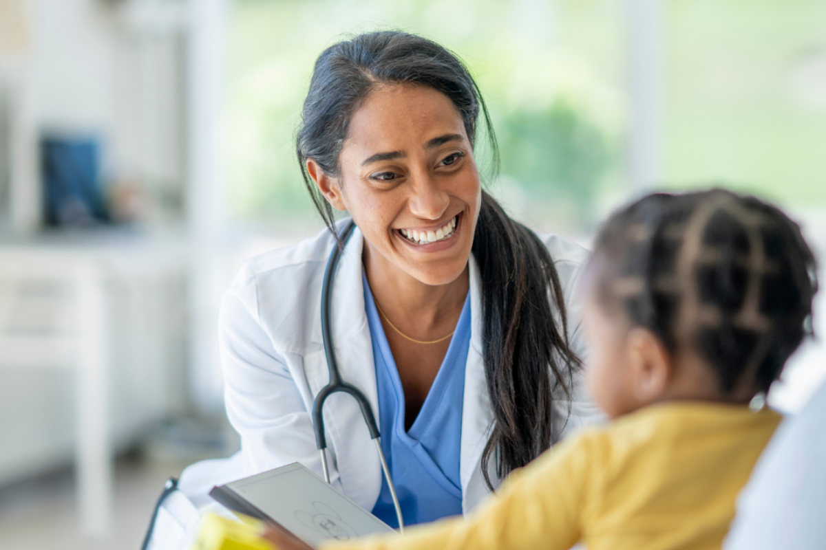 Doctor talking to young child during medical visit.